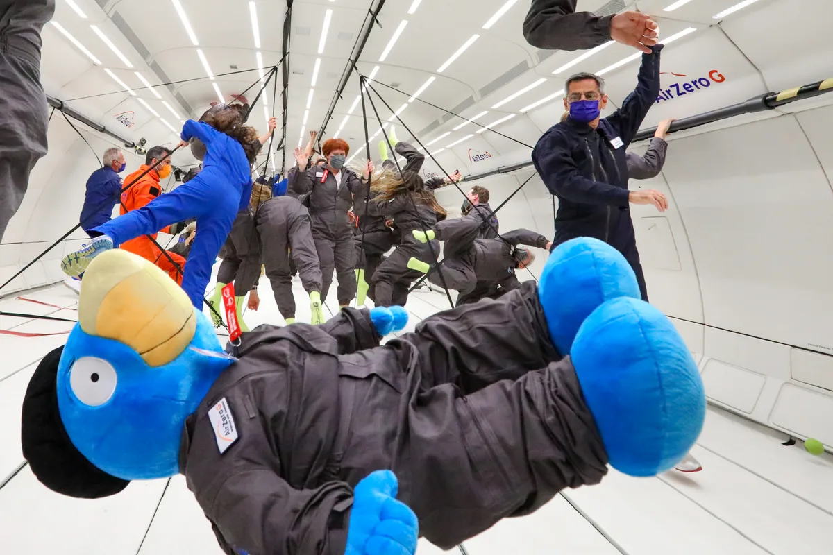 Ein grosser Plüsch-Globi schwebt bei einem Parabelflug durch die Luft.